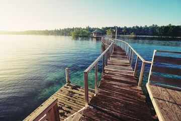  Beautiful landscape. Sunset on the seashore. Wooden bridge on the beach, Siargao Island, Philippines.