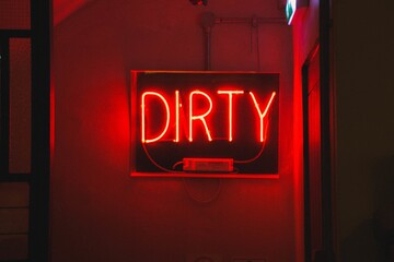 Wall Mural - closeup shot of a red neon light sign with the text [dirty]
