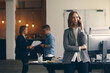 © Martin Villadsen - Female  entrepreneur talking on the phone with coworkers in the background