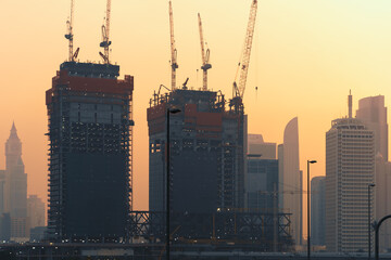 Wall Mural - Construction of new modern tower buildings in Dubai at sunset, UAE.