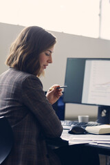 Close up of beautiful business woman wearing a suit while working in front of her computer 