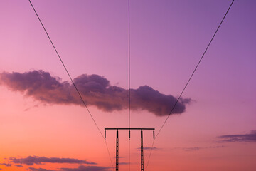 Silhouette of high voltage power lines at sunset. Electric transmission tower. Electricity concept