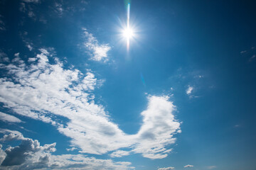 sun shining in almost totally clear blue sky, clearing sky.