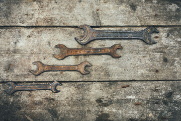 Rusty wrenches on a wooden background. Old keys