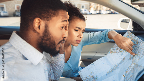 Concerned Black Couple Looking At Map Sitting In Auto, Panorama