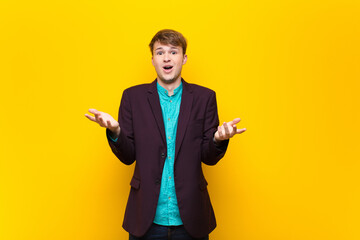 Wall Mural - young blonde man feeling extremely shocked and surprised, anxious and panicking, with a stressed and horrified look isolated against flat wall