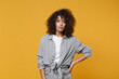 © ViDi Studio - Young african american woman girl in gray casual clothes posing isolated on yellow background studio portrait. People emotions lifestyle concept. Mock up copy space. Standing with arm akimbo on waist.