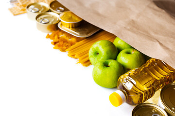 Wall Mural - Food delivery, Donation. Food supplies crisis food stock for quarantine isolation period on white background. Pasta, canned food, apples, oil, crackers.