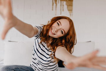 ecstatic red-haired girl making selfie and laughing. emotional caucasian lady in casual attire expre