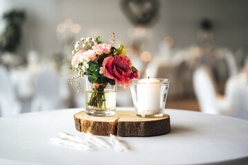 Wall Mural - Elegant festive table setting with colorful flowers and candle on wooden stand. Wedding table decoration.