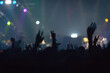 © Keopaserth - Concert crowd attending a concert, people silhouettes are visible, back lit by stage lights. Raised hands