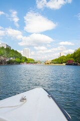 Poster - First-person view of a moving boat with an overlook to a city during daytime