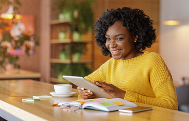 Wall Mural - Cheerful african girl using social media on digital tablet