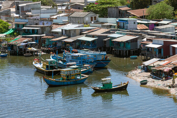 Wall Mural - View of waterfront area of Phan Thiet in central Vietnam featuring boats bridges and buildings. The town is damous for fishing, fish sauce and tourism