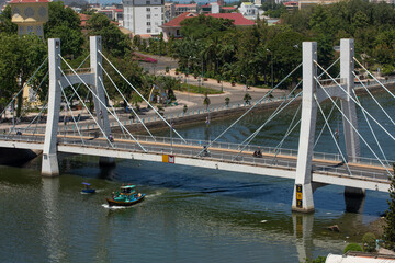 Wall Mural - View of waterfront area of Phan Thiet in central Vietnam featuring boats bridges and buildings. The town is damous for fishing, fish sauce and tourism