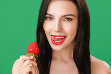 Wall Mural - Sexy young woman with strawberry on color background