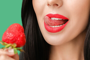 Wall Mural - Sexy young woman with strawberry on color background, closeup