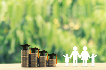 Family members, rows of rising coins with graduation cap or hat on a table. Saving money for kid, child education concept depicts increasing in cost for paying tuition fee when study higher class