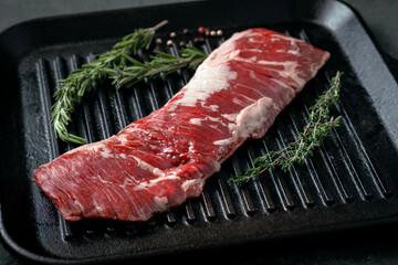 Wall Mural - Raw machete steak on beef in a grill pan with seasoning. Stone background.