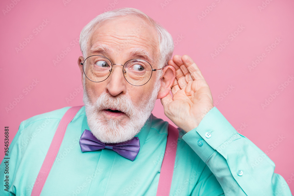 Closeup photo of attractive grandpa hand near ear listen rumors focused chatterbox bad person wear specs mint shirt suspenders violet bow tie isolated pink pastel color background - obrazy, fototapety, plakaty 