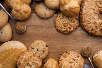 different sweet pastries on a wooden board. Cookies, bun, muffins, tartlets, cupcakes and eclairs
