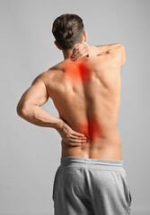 Wall Mural - Man suffering from pain in neck and lower back on light grey background