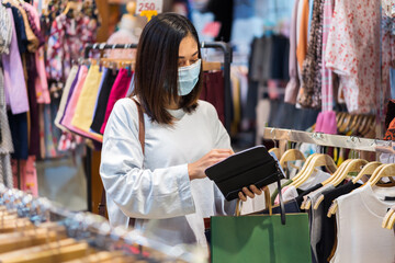 Sticker - woman open purse to payment for clothes at shopping store and her wearing medical mask for prevention from coronavirus (Covid-19) pandemic. new normal concepts