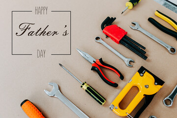 Tools top view on craft paper. Father's day card with tools. Plier, open wrenches, screwdrivers and staple gun flat lay.