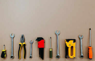 Wall Mural - Tools top view on craft paper. Plier, open wrenches, screwdrivers and staple gun flat lay with copy space.