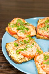 Poster - Vertical high angle closeup shot of fresh bruscetta with cheese, tomatoes, and basil on a blue plate