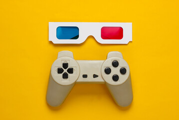 Anaglyph disposable paper 3d glasses and retro gamepad on yellow background. Top view