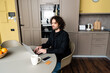 © LIGHTFIELD STUDIOS - smiling freelancer typing on laptop near smartphone with blank screen, credit card and coffee cup