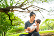 © themorningglory - Mother hold carry infant baby boy sitting under tree branch