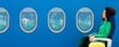 © LIGHTFIELD STUDIOS - panoramic shot of smiling african american woman sitting on seat near travel bag and portholes on blue