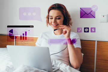 Wall Mural - smiling freelancer making video call with headset and laptop in bed during quarantine with business signs