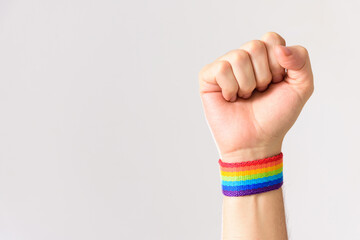 closed fist against homophobia. closed fist with colorful rainbow flag wristbands. Proud gay man. Gay month.