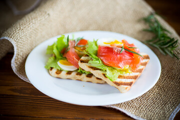 Wall Mural - fried bread toast with salad leaves and salted red fish