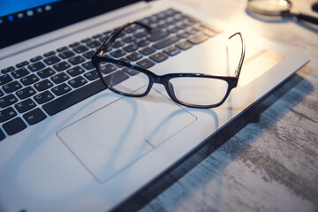 Poster - glasses on the computer keyboard on table