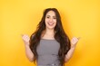 Closeup of young optimistic female isolated on grey background showing thumbs up with positive emotions of content and happiness. Copyspace, concept of satisfaction with quality and recommendation.