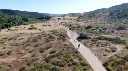 Wall Mural - Aerial view of Los Penasquitos Canyon Preserve with tourists, hikers and bikers on the trails,. Urban park with mountain, forest and trails in San Diego, California. USA