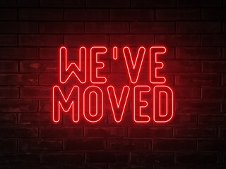 Wall Mural - We've moved - red neon light word on brick wall background