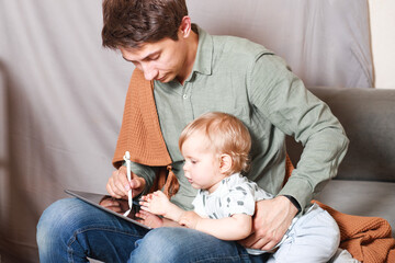 Work from home. This is a developer working on a tablet computer with children in quarantine