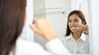 © PK Studio - Portrait of a beautiful young woman brushing teeth in the bathroom.