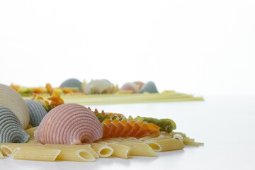 Poster - Closeup shot of delicious colorful organic Italian pasta and spaghetti on a blurred background