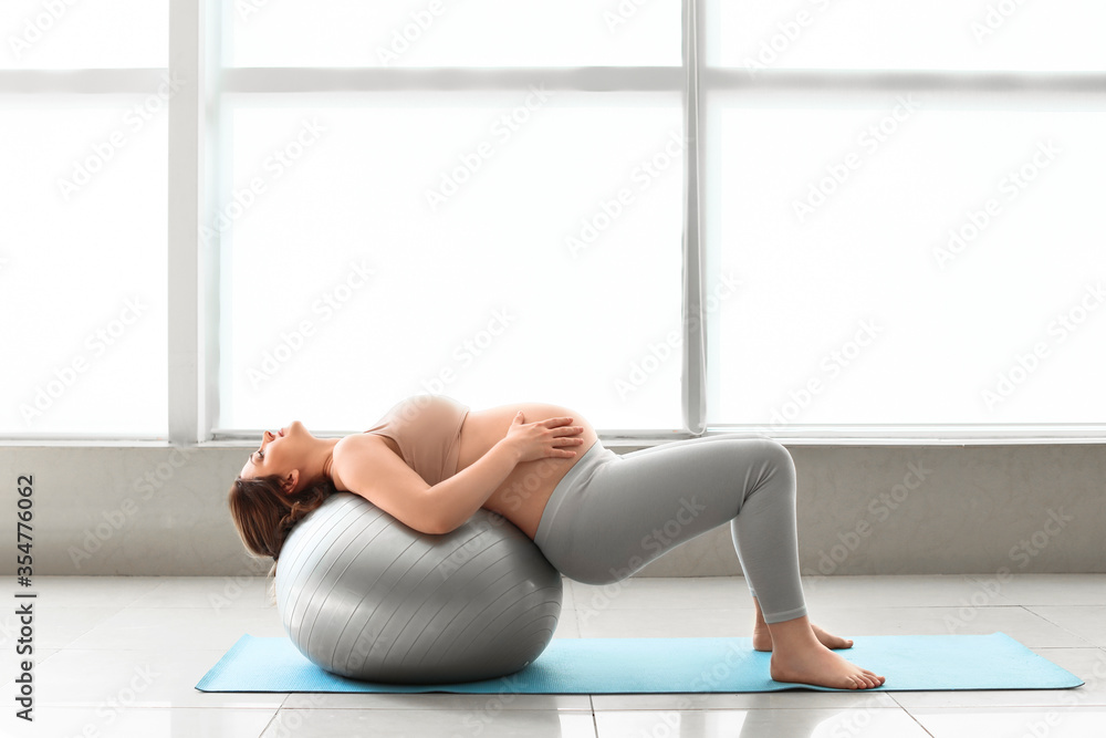 Young pregnant woman training in gym