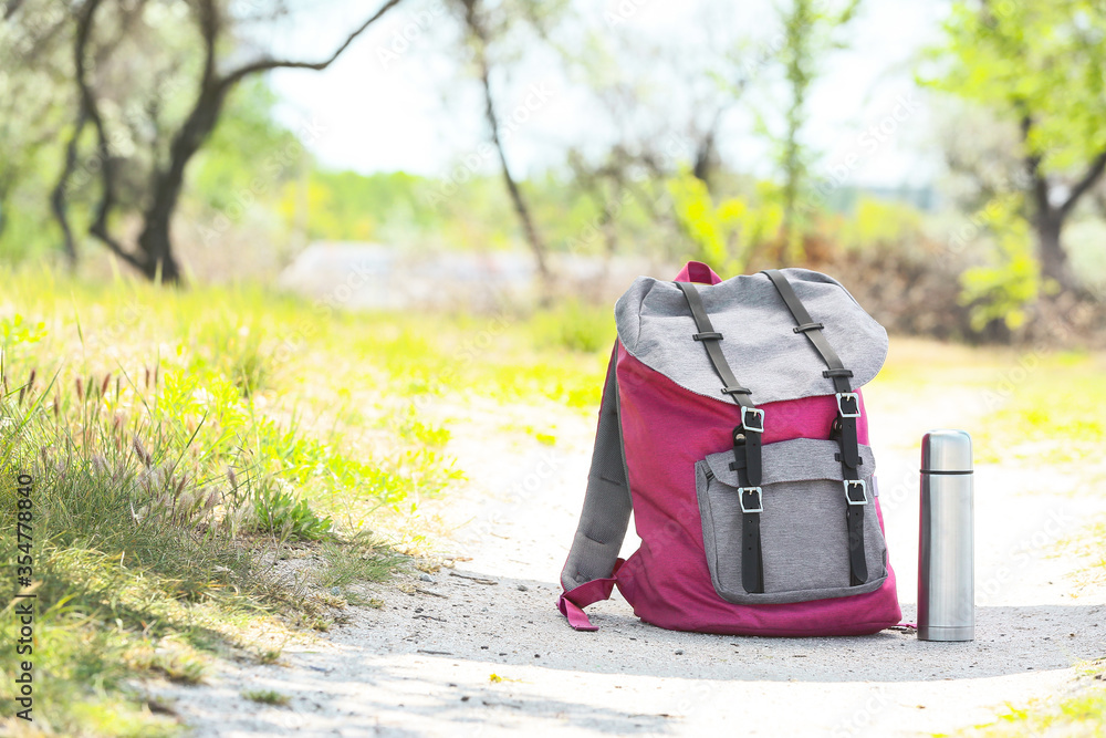 Traveler's backpack and thermos bottle outdoors