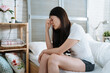 © PR Image Factory - illness asian chinese lady wake up in the morning with migraine. Insomnia results in headaches when awakened. sickness young girl feeling stressed and massage nose bridge sitting on bed in bedroom.
