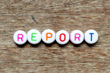 Wall Mural - White bead with color letter in word report on wood background