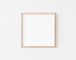 Thin square wooden frame on white wall. 3d illustration.