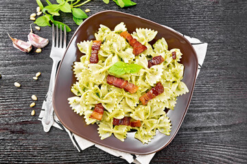 Wall Mural - Farfalle with pesto and bacon on dark board top